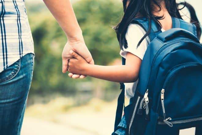 Mother daughter on way to school with backpack