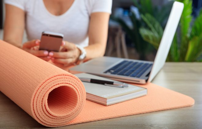 Employee at desk with computer, phone and yoga mat