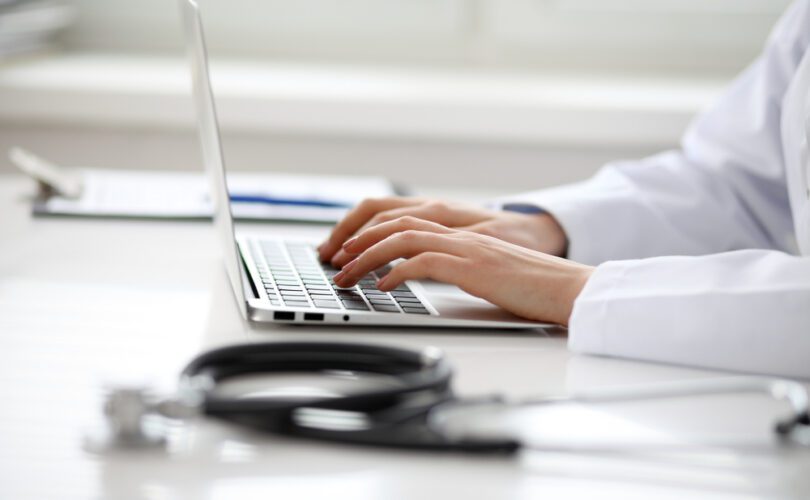 Photo of a doctor at sitting at the computer