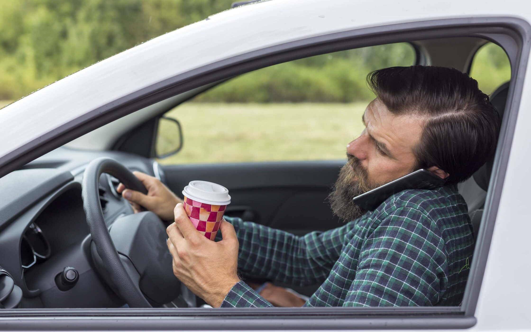 Young man talking on the phone while driving