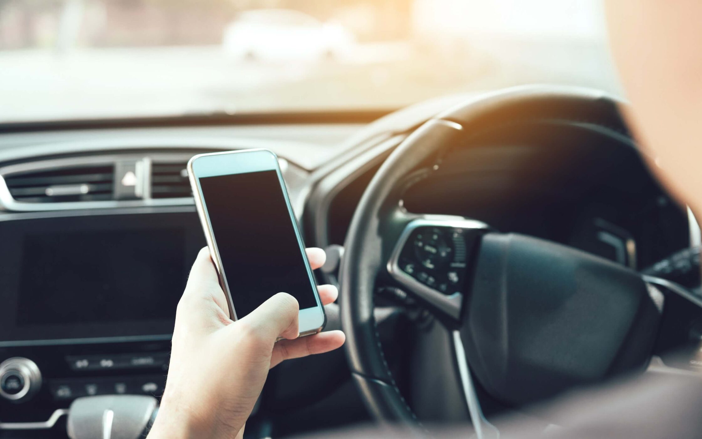 Man hand is using the phone while driving